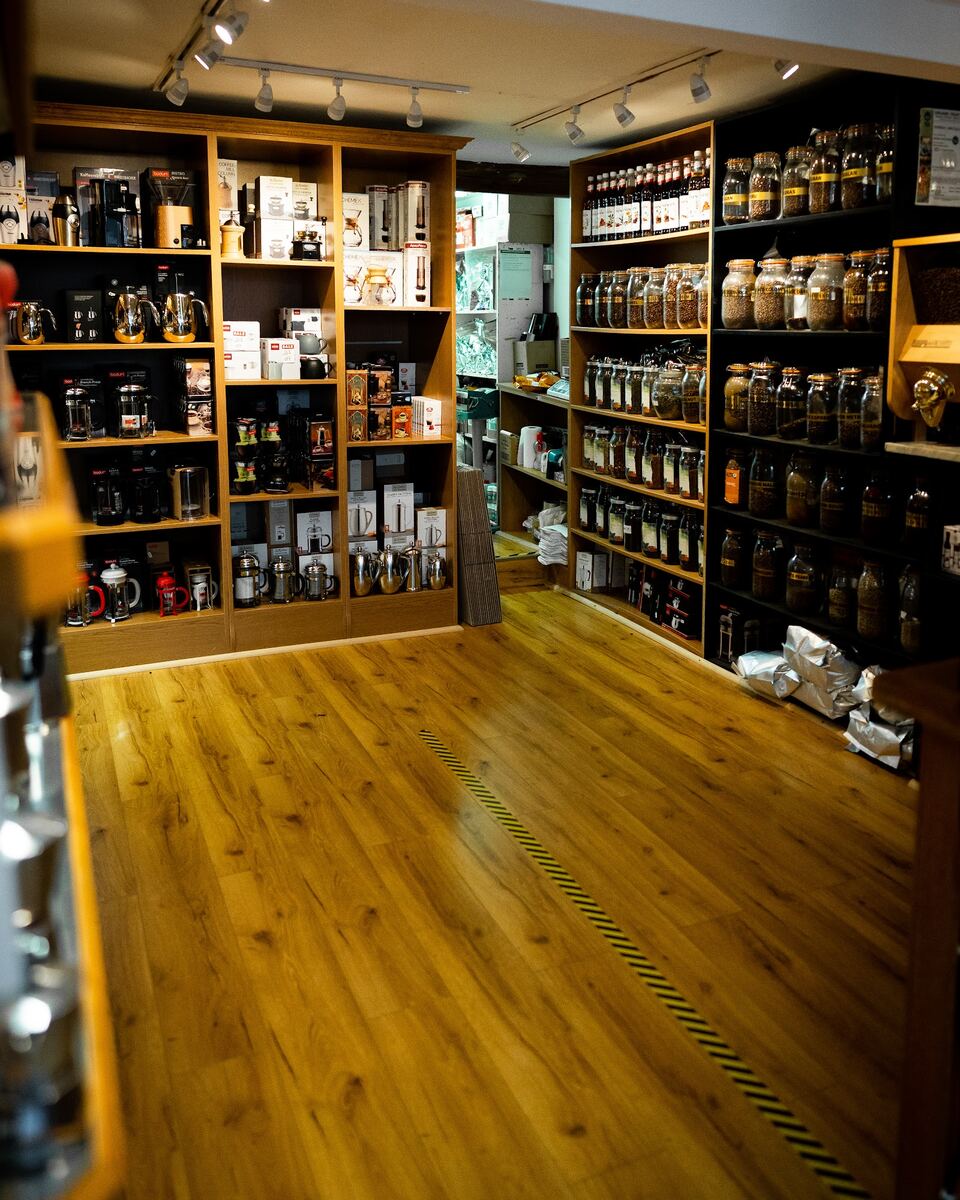 Shop interior with shelves of coffee kit on the left, jars of beans on the right and an oak floor